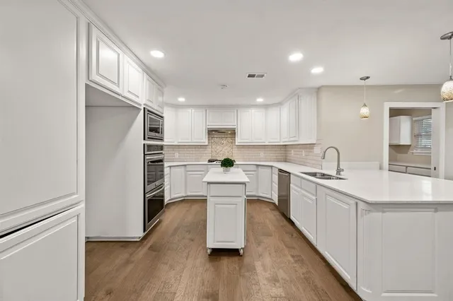 a kitchen with white cabinets and stainless steel appliances