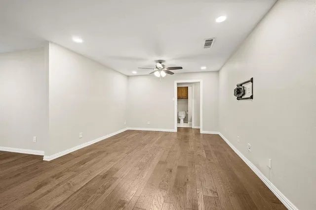 a view of an empty room with wooden floor