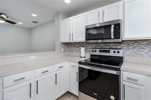 a kitchen with white cabinets and appliances