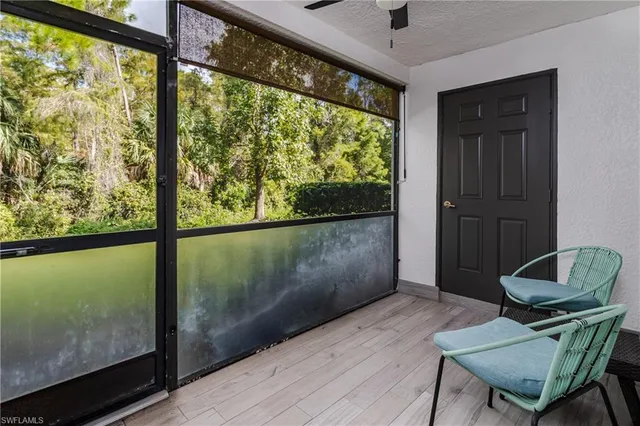 a living room with a large window and wooden floor
