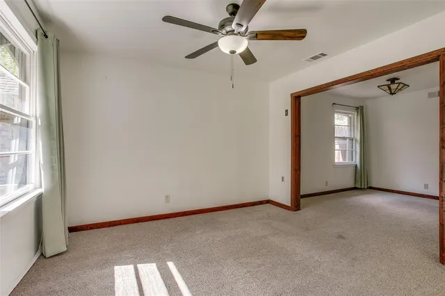 a view of a big room with chandelier fan and windows