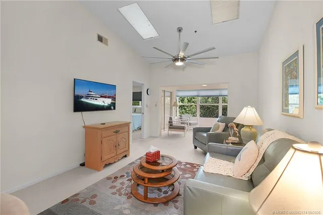 a living room with furniture a flat screen tv and a large window