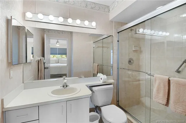 a bathroom with a sink toilet a mirror and shower