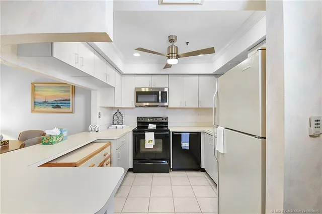 a kitchen with stainless steel appliances granite countertop a refrigerator a stove a sink dishwasher and a refrigerator with wooden floor