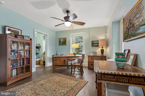 a living room with furniture a bookshelf and a window
