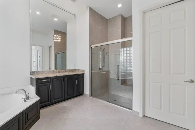 a bathroom with a bathtub shower sink and mirror