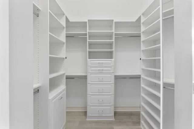 a view of walk in closet with empty racks
