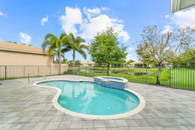 a view of a swimming pool with a yard and plants