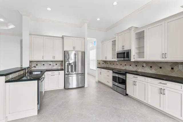 a kitchen with stainless steel appliances granite countertop a refrigerator and a stove