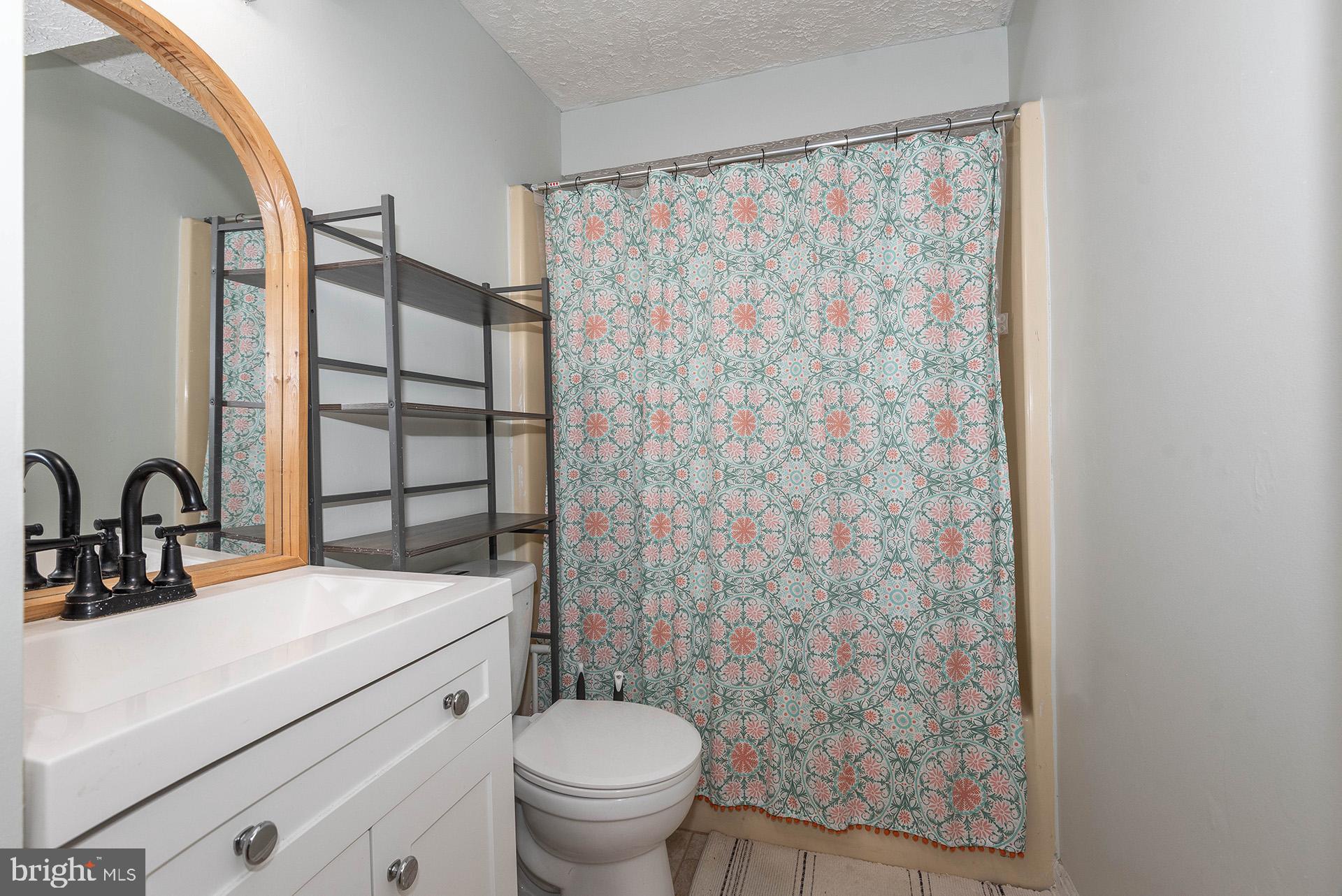 7523 Harmans Road Harmans, MD 21077 - Photo 24 of 27 a bathroom with a granite countertop sink a toilet and shower curtain