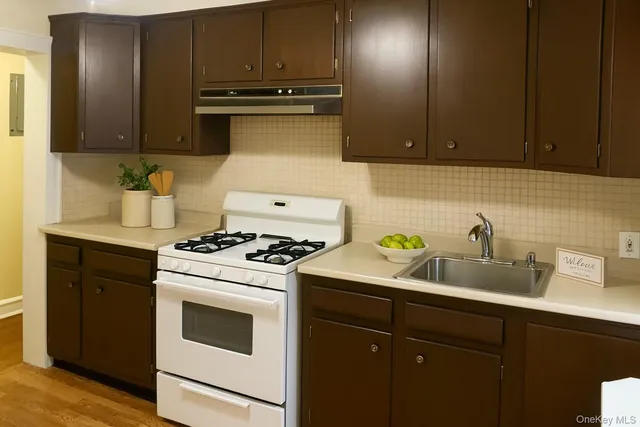 a kitchen with sink a stove and cabinets