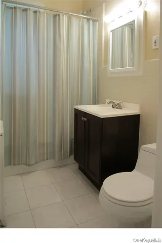 a bathroom with a sink vanity mirror and toilet