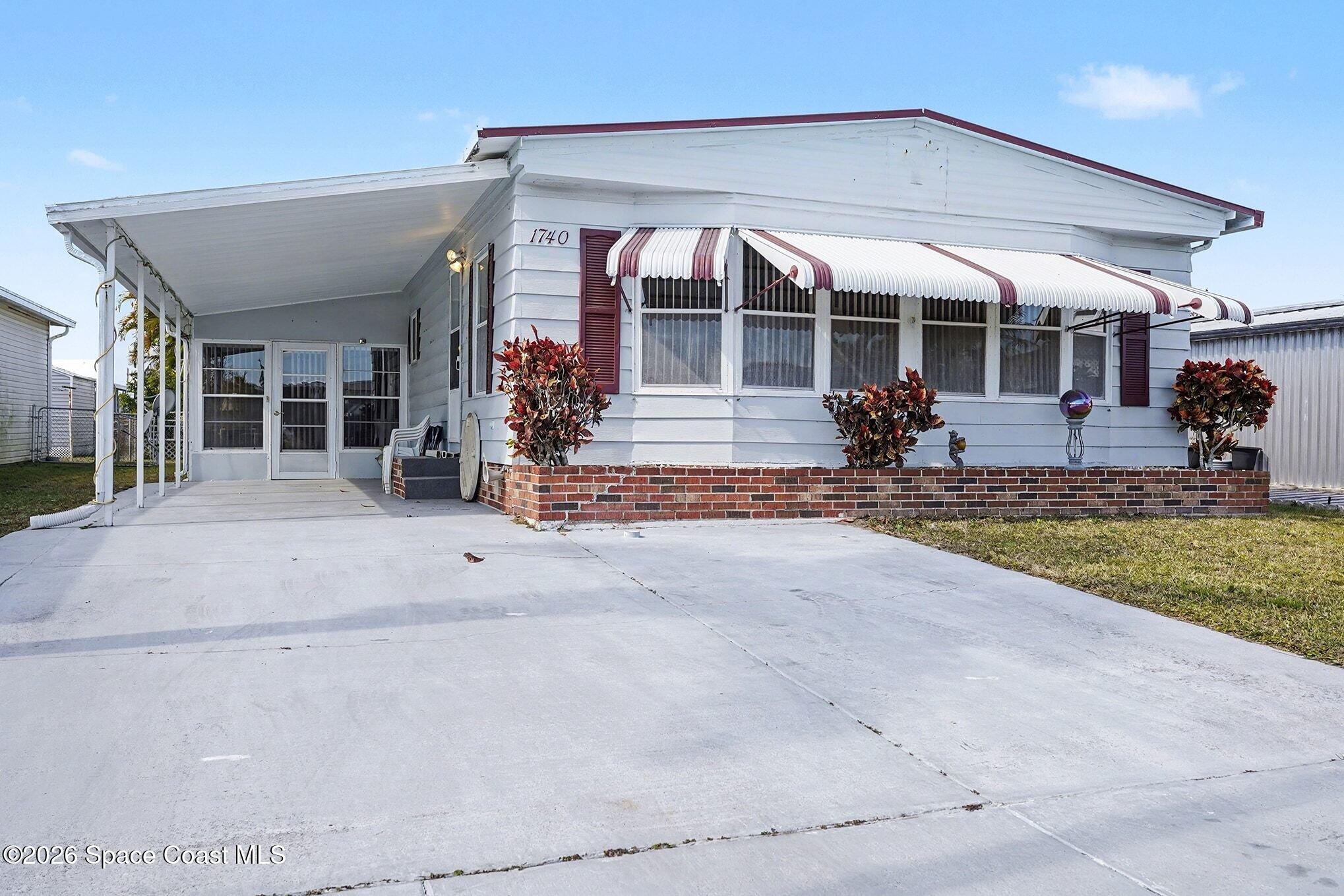 1740 Coco Plum Street Northeast Palm Bay, FL 32905 - Photo 1 of 33 a view of a house with backyard porch and sitting area
