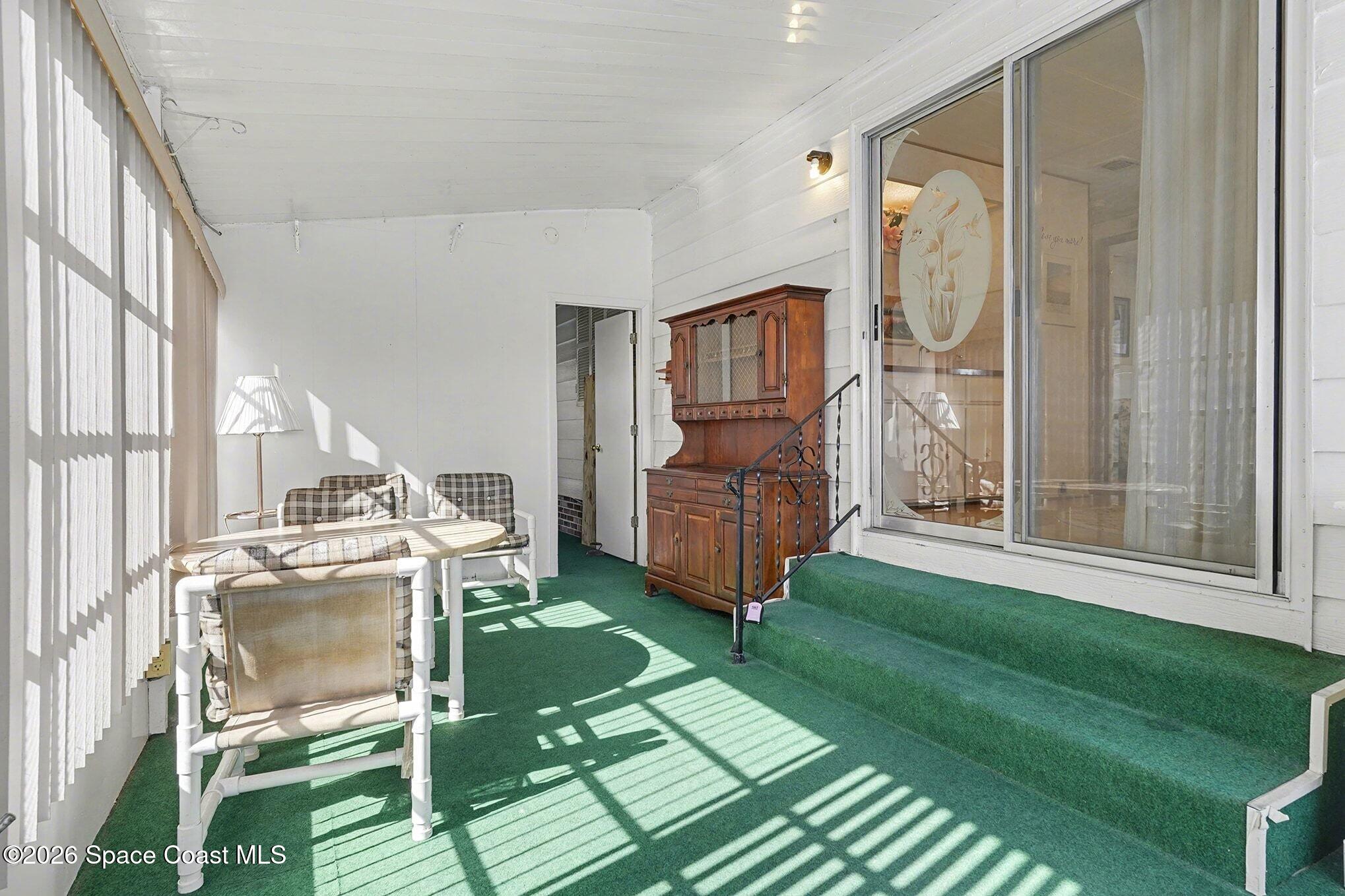 1740 Coco Plum Street Northeast Palm Bay, FL 32905 - Photo 16 of 33 a living room with a baby crib furniture and a floor to ceiling window