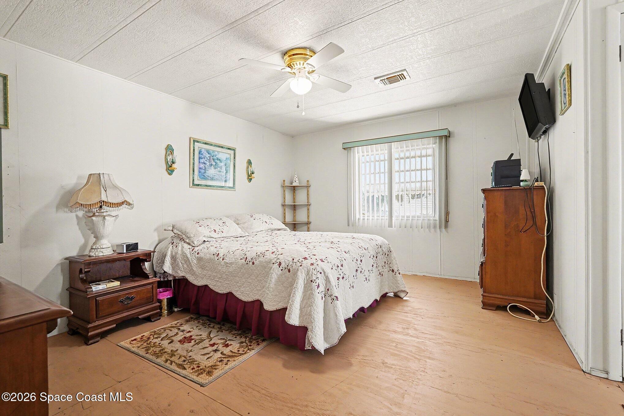1740 Coco Plum Street Northeast Palm Bay, FL 32905 - Photo 18 of 33 a bedroom with a bed and a chandelier