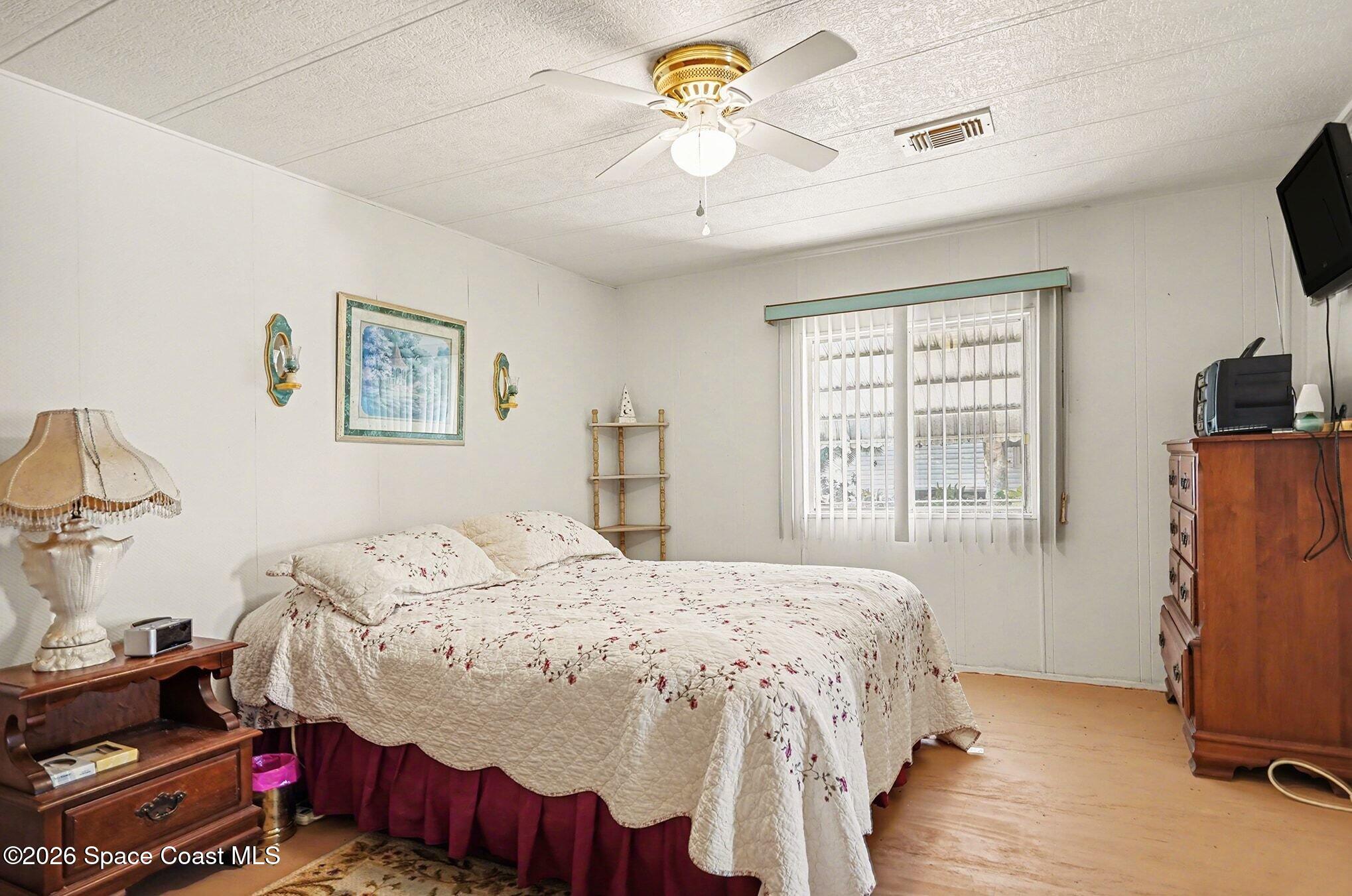 1740 Coco Plum Street Northeast Palm Bay, FL 32905 - Photo 19 of 33 a bedroom with a bed and a chandelier