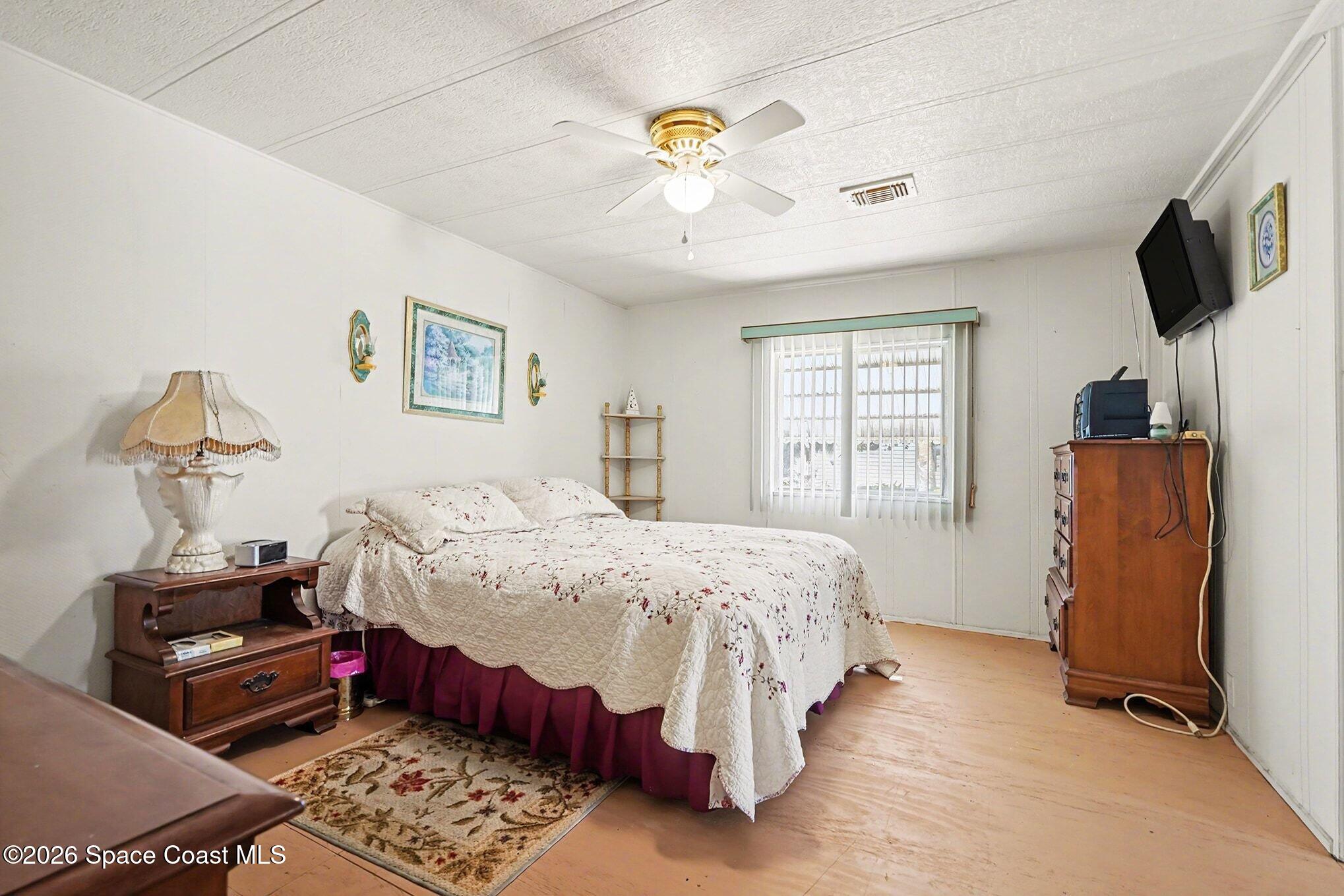 1740 Coco Plum Street Northeast Palm Bay, FL 32905 - Photo 20 of 33 a bedroom with bed and tv
