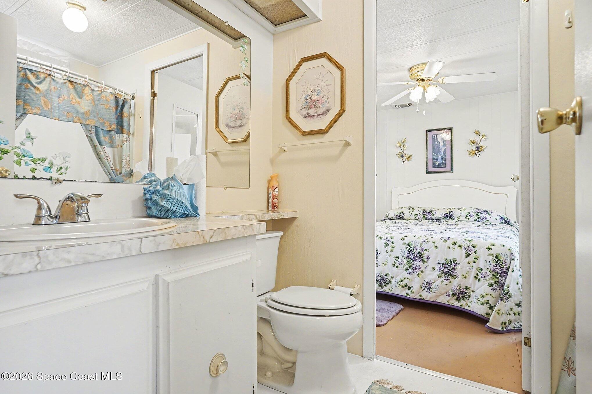 1740 Coco Plum Street Northeast Palm Bay, FL 32905 - Photo 26 of 33 a bathroom with a toilet sink and mirror