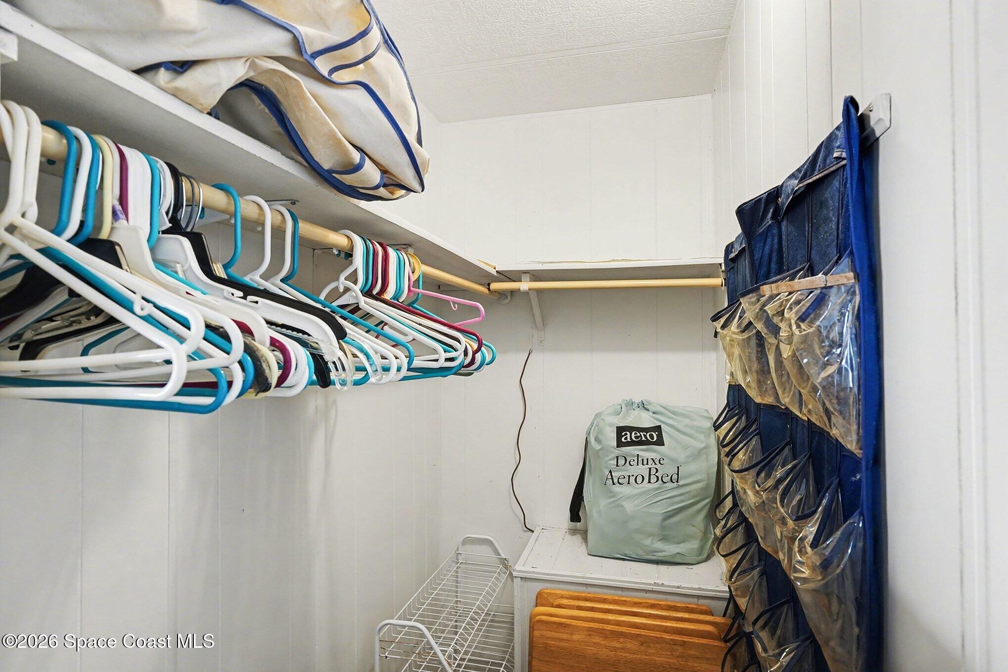 1740 Coco Plum Street Northeast Palm Bay, FL 32905 - Photo 27 of 33 a view of walk in closet with clothes and shoes