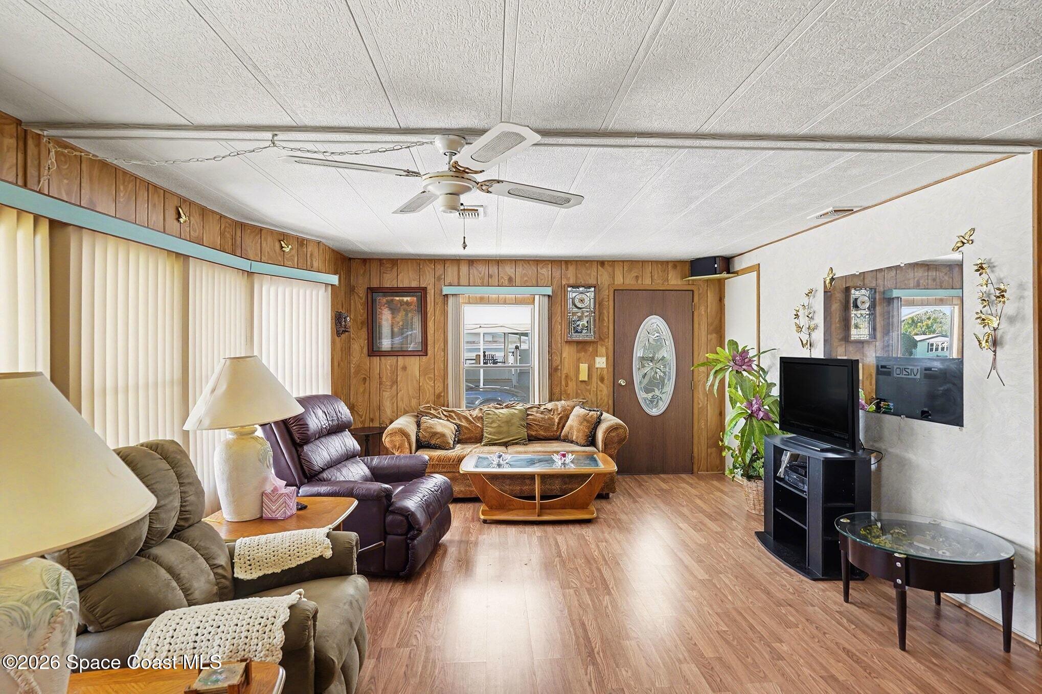 1740 Coco Plum Street Northeast Palm Bay, FL 32905 - Photo 6 of 33 a living room with furniture a ceiling fan and a flat screen tv