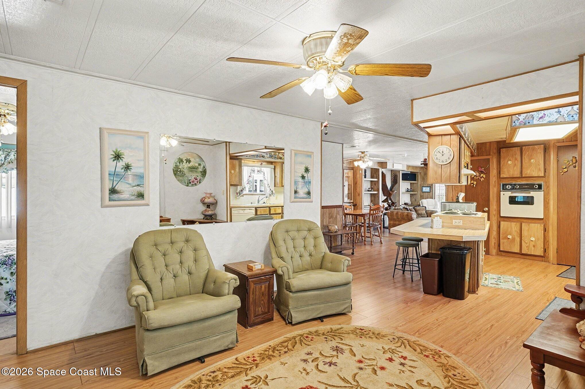 1740 Coco Plum Street Northeast Palm Bay, FL 32905 - Photo 7 of 33 a living room with furniture kitchen view and a chandelier