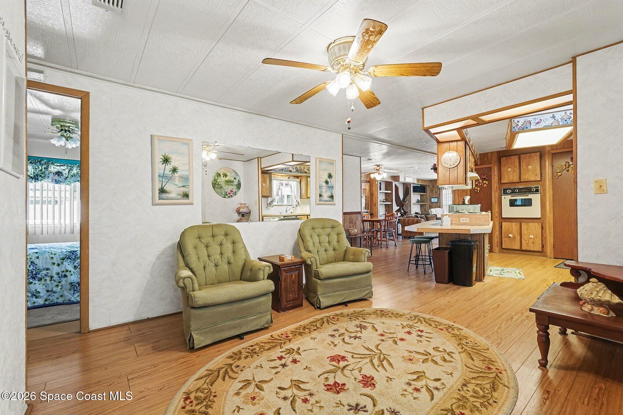 1740 Coco Plum Street Northeast Palm Bay, FL 32905 - Photo 8 of 33 a living room with furniture and a chandelier