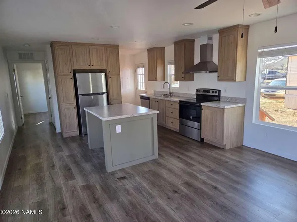 a kitchen with a sink cabinets stainless steel appliances and window