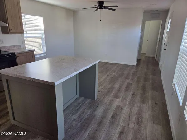 a view of kitchen with a sink wooden floor and window