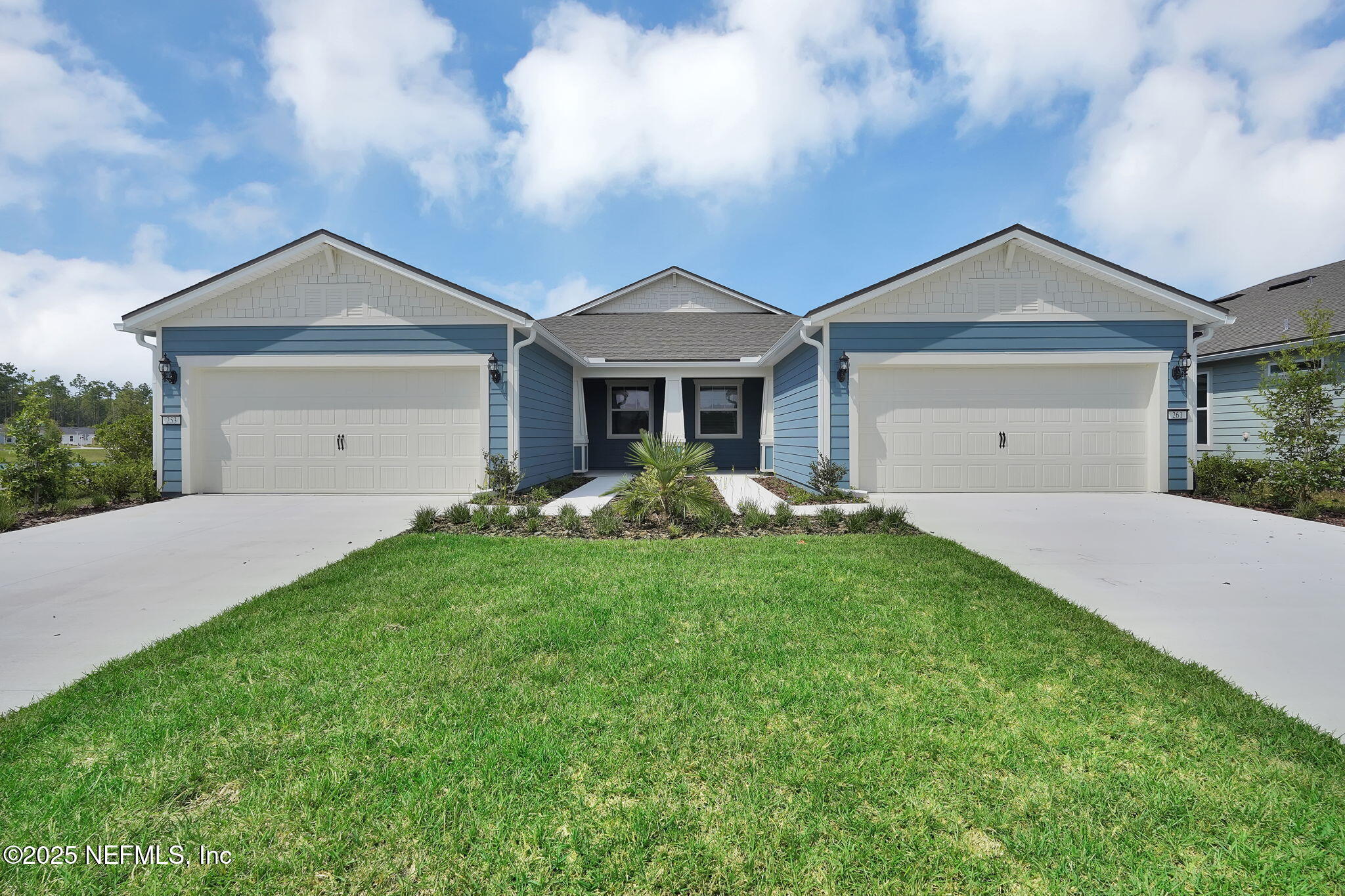 a view of a house with a yard and large tree