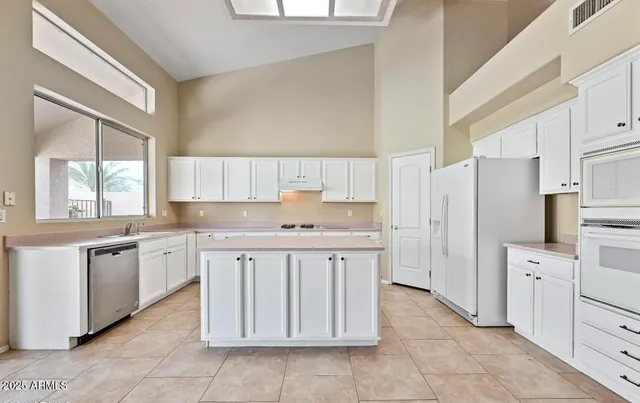 a kitchen with granite countertop a white stove top oven and refrigerator