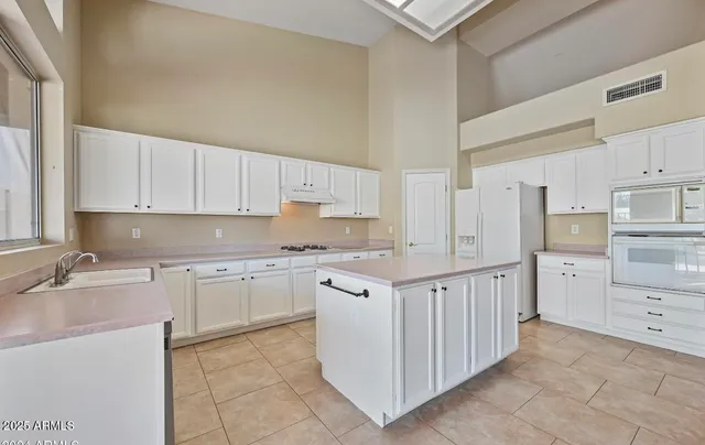 a kitchen with white cabinets and appliances