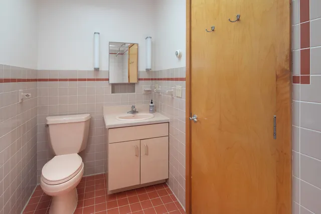 a bathroom with a toilet sink and mirror