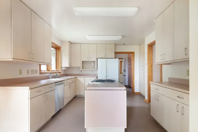 a kitchen with white cabinets and white appliances