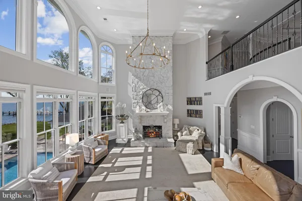 a living room with furniture a fireplace and a chandelier