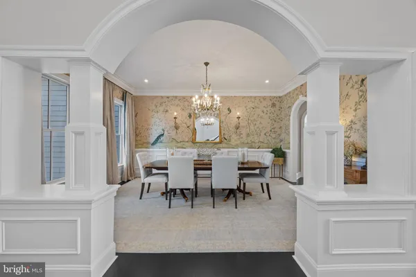 a dining room with furniture a chandelier and kitchen view