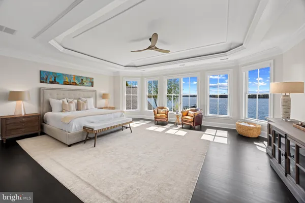 a bedroom with a bed chandelier and a window