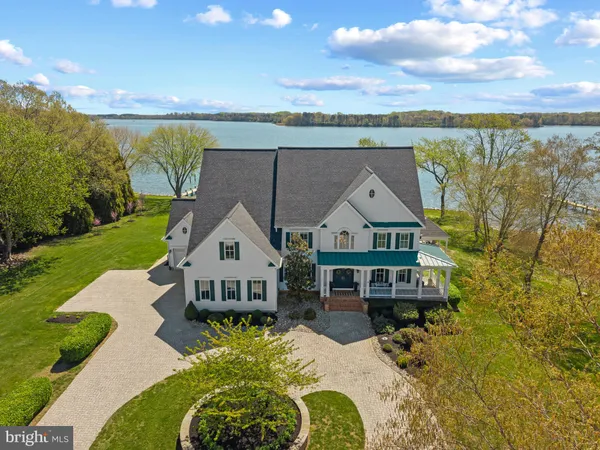 an aerial view of a house with a big yard and large trees