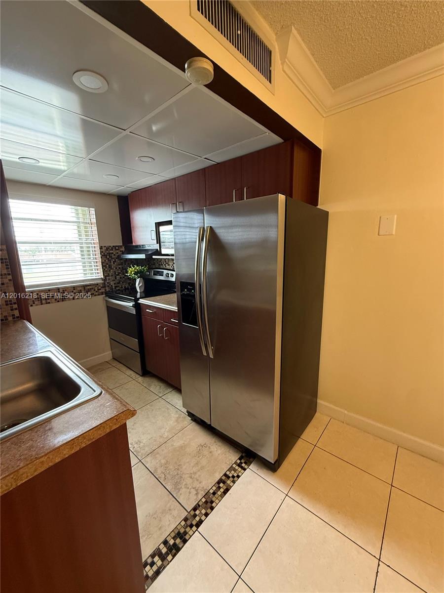 9321 Southwest 4th Street, Unit 230C Miami, FL 33174 - Photo 15 of 37 a kitchen with stainless steel appliances granite countertop a refrigerator and a stove