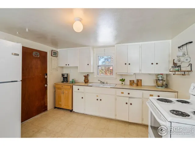 a kitchen with granite countertop a sink stove and refrigerator