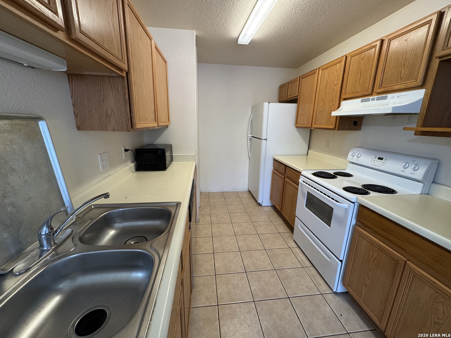 7921 M G Road San Antonio, TX 78251 - Photo 3 of 10 a kitchen with a sink a stove and cabinets