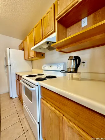 a kitchen with a sink a stove top oven and cabinets