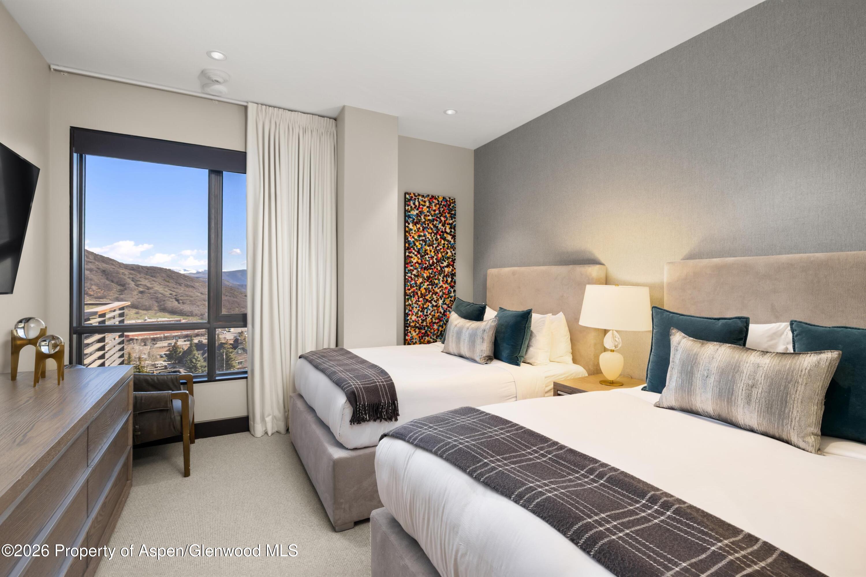 77 Wood Road, Unit 703 EAST Snowmass Village, CO 81615 - Photo 14 of 21 a spacious bedroom with a bed and a large window