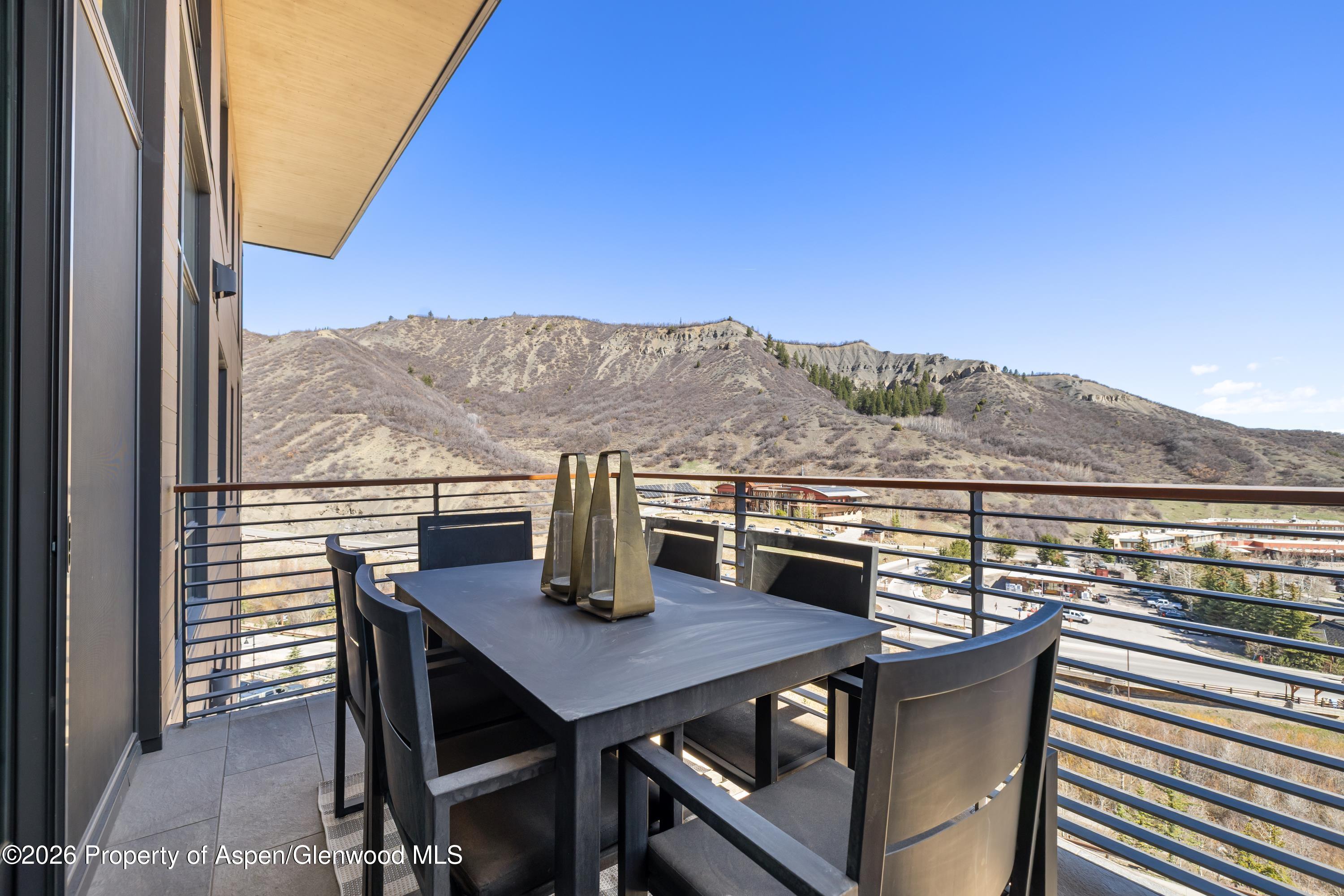 77 Wood Road, Unit 703 EAST Snowmass Village, CO 81615 - Photo 7 of 21 a view of a balcony with table and chairs