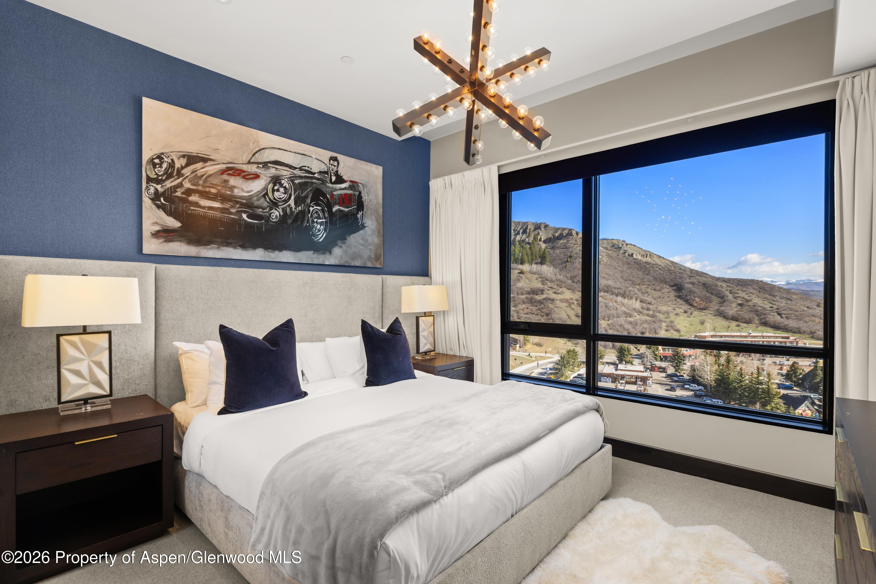 77 Wood Road, Unit 703 EAST Snowmass Village, CO 81615 - Photo 9 of 21 a bedroom with a large bed and a large window with the view of balcony