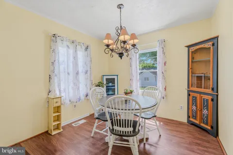 a dining room with furniture wooden floor a chandelier