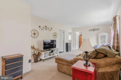 a living room with furniture a flat screen tv and gym equipment