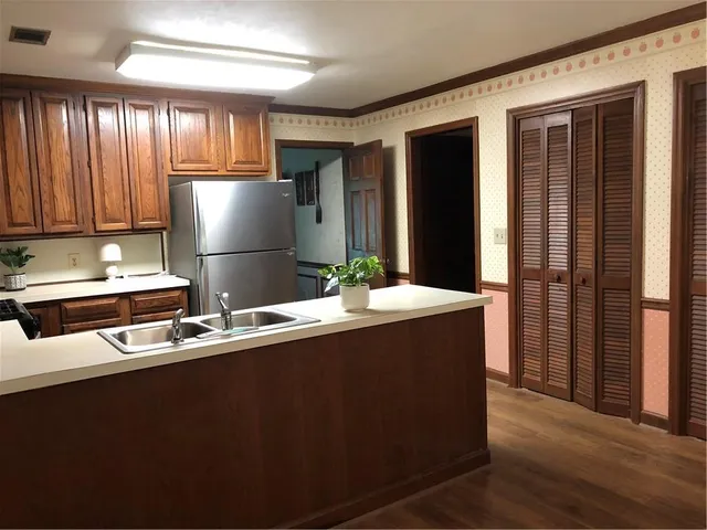 a kitchen with stainless steel appliances granite countertop a refrigerator a sink and a stove