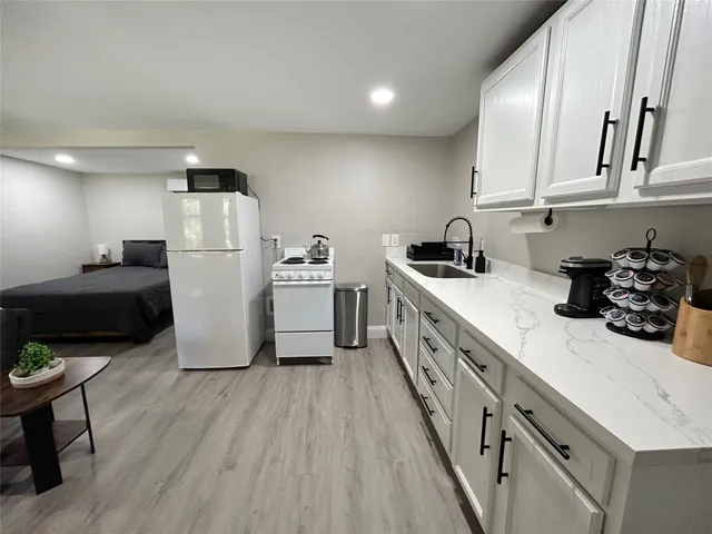 a kitchen with sink a refrigerator and microwave