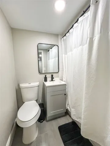 a bathroom with a toilet a sink and a mirror