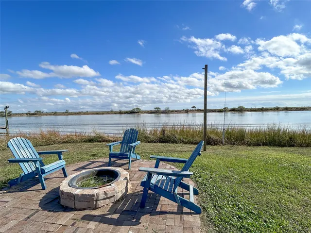 a view of a lake with couches chairs and a yard
